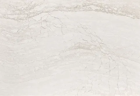 White marble surface with light beige veining and cracks.