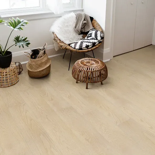 Wooden floor in a room with a wicker chair, plant, and baskets.