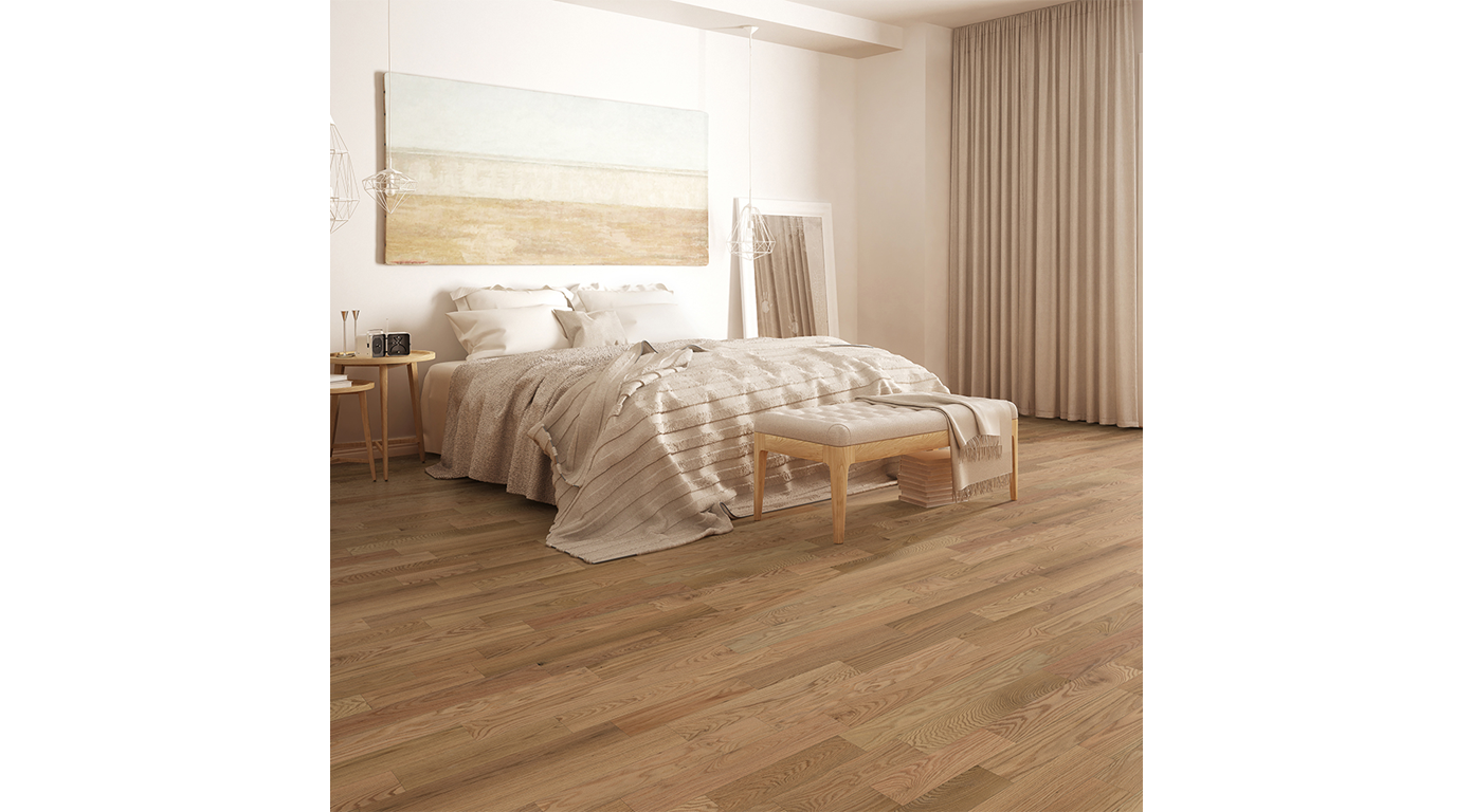 Bedroom with wooden floors, bed with beige bedding, large artwork, mirror, and curtains.