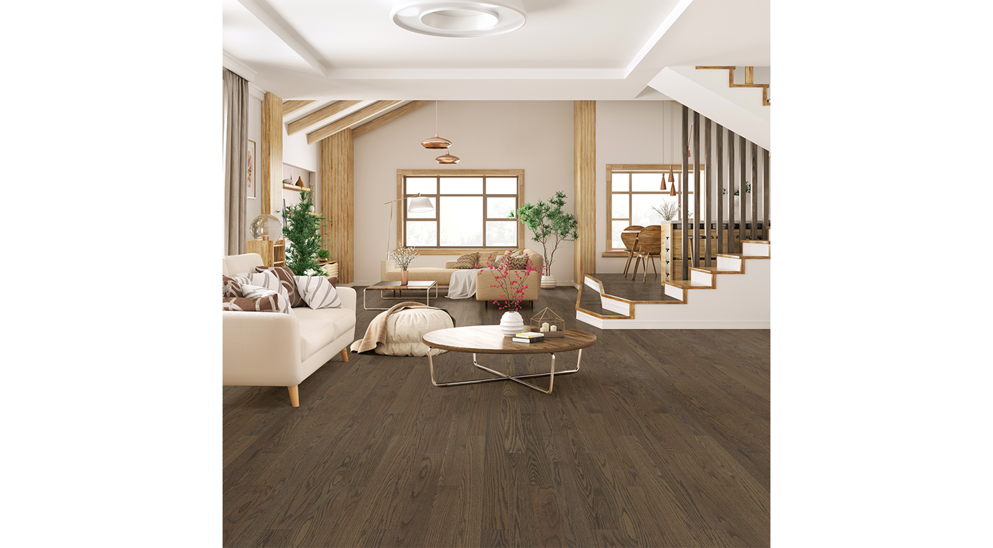 Spacious living room with dark wood floors, beige walls, and a staircase. Sunlight floods the space.