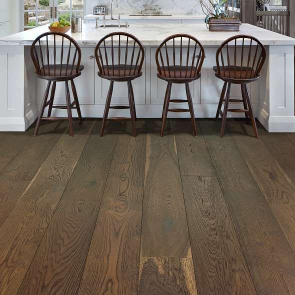 Dark wood floor with a kitchen island and four bar stools.