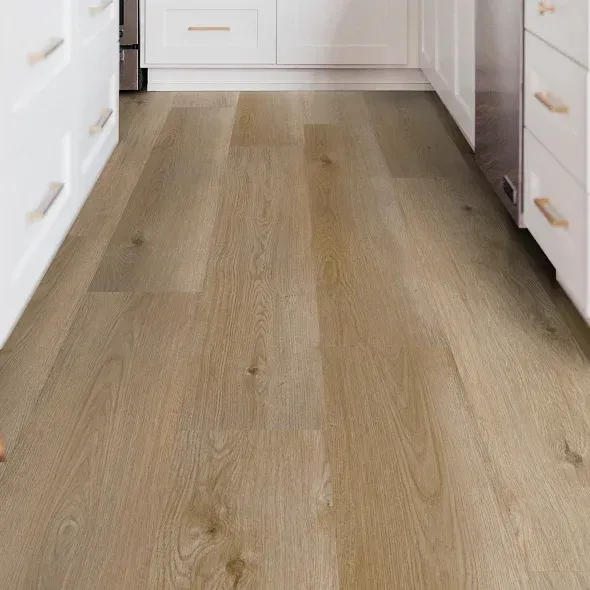Wooden-look flooring in a kitchen, with white cabinets and gold handles.