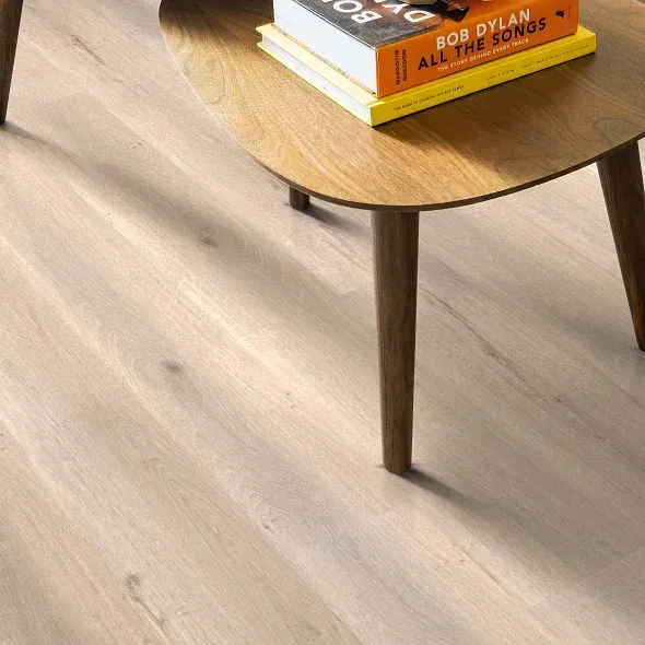 Light wood-look flooring with a wooden coffee table holding books.