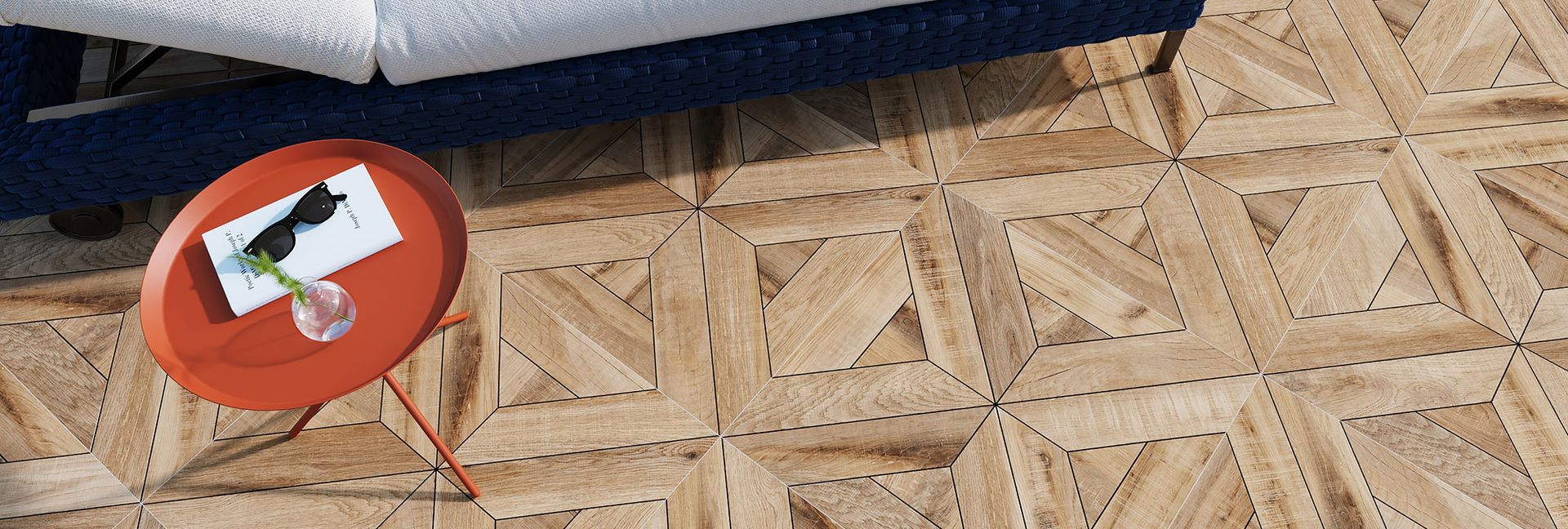 An orange side table with items on top, set on a wooden floor with a geometric pattern.