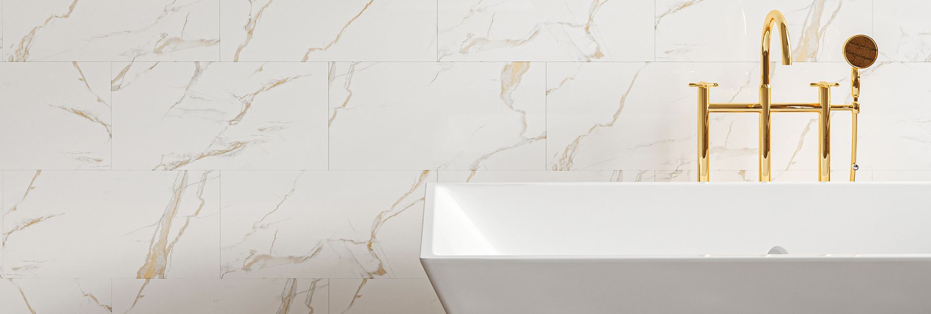 A white bathtub with gold fixtures against a marble wall.