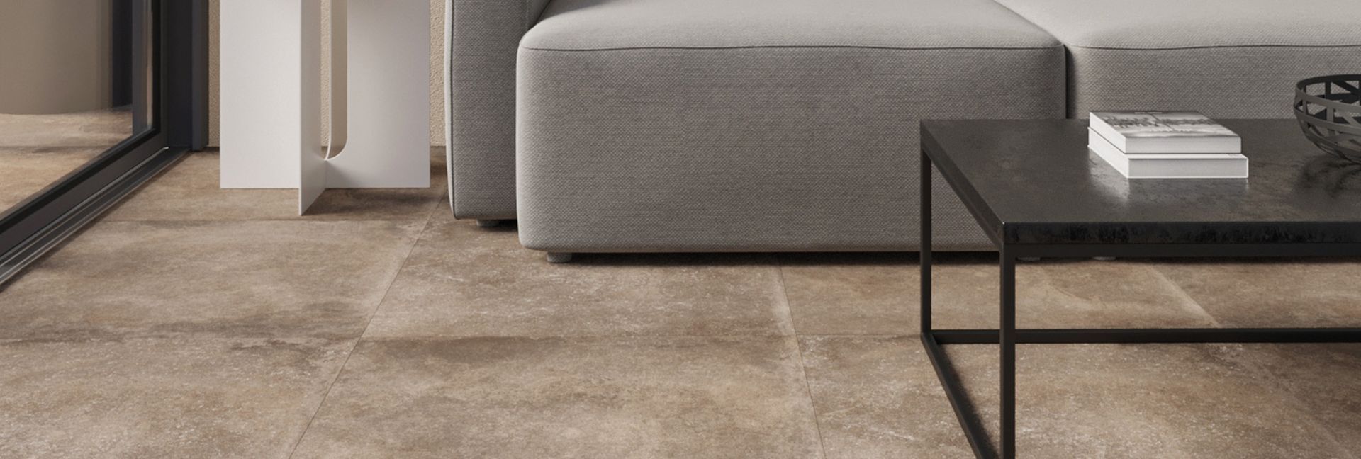 Living room with a stone floor, gray couch, and black coffee table.