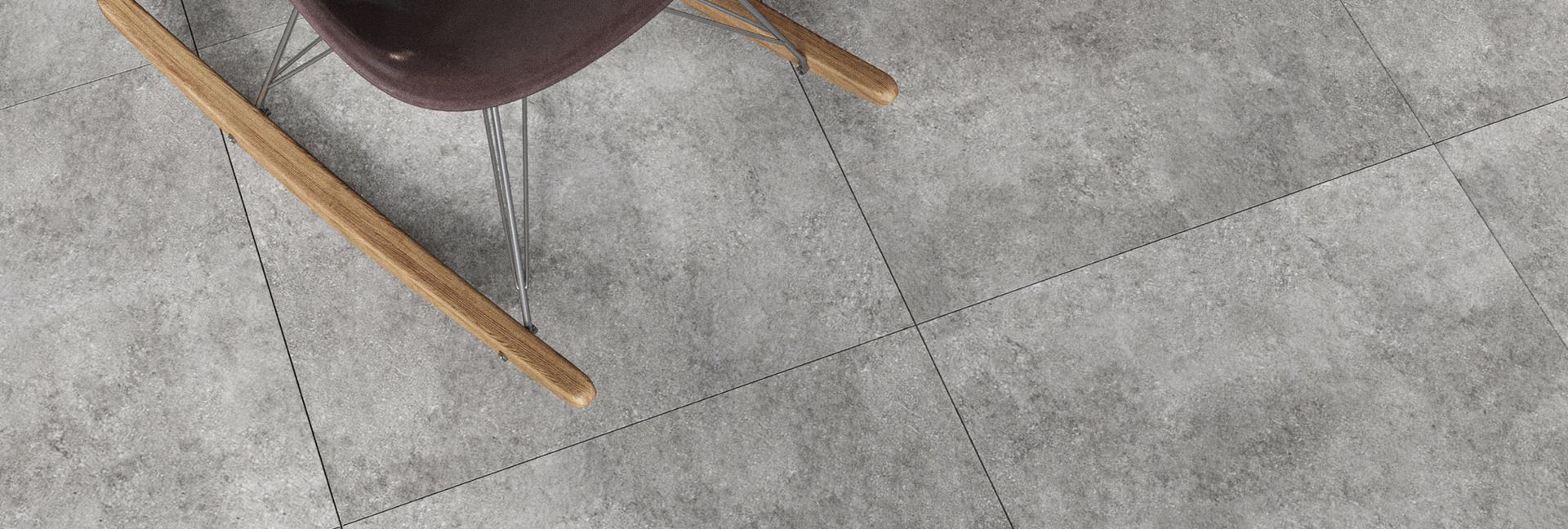 Chair leg resting on a grey, textured floor with dotted lines.