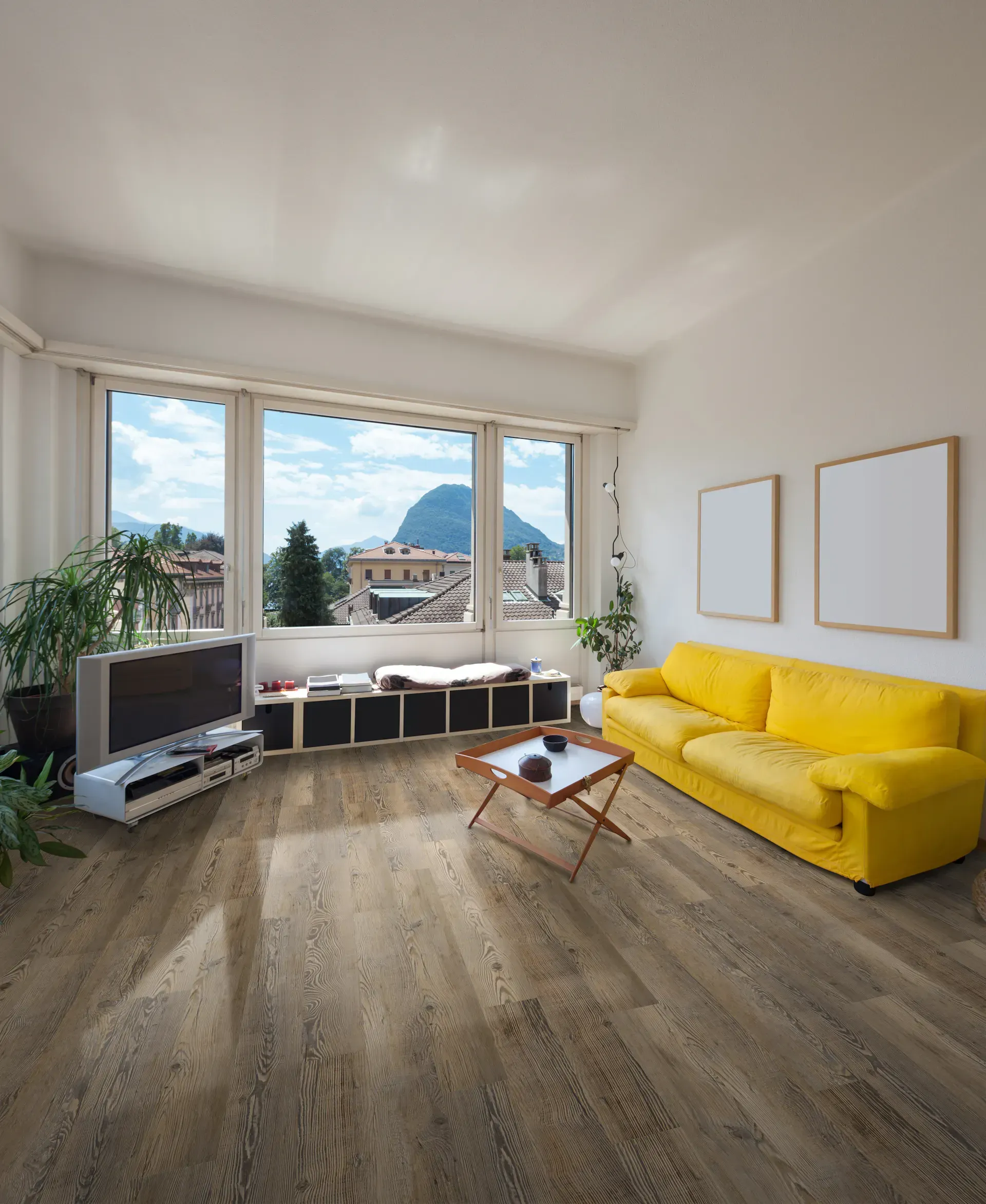 Living room with yellow sofa, large windows, and wooden flooring. Mountain view.