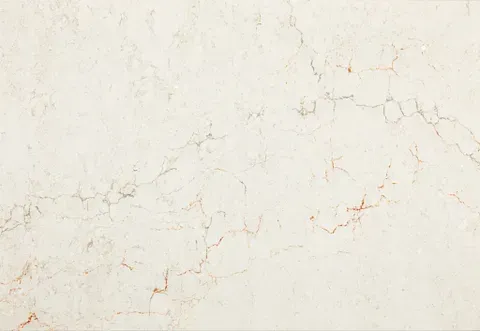 Cream-colored marble surface with subtle reddish-brown veining and natural cracks.