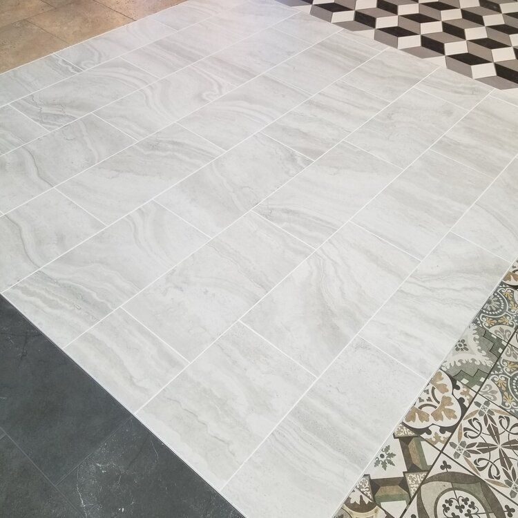 Light gray tile floor with a marble-like pattern, other tile samples in various patterns and colors.