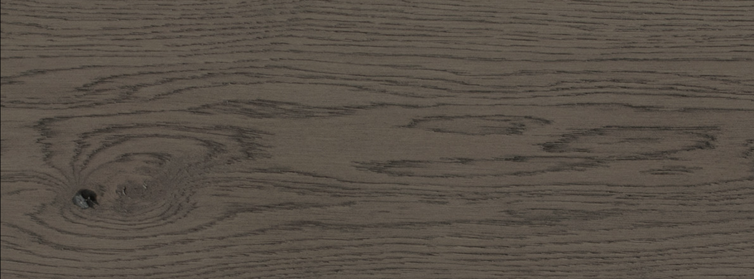 Close-up of a wooden surface in various shades of gray. The grain is visible with a dark knot.