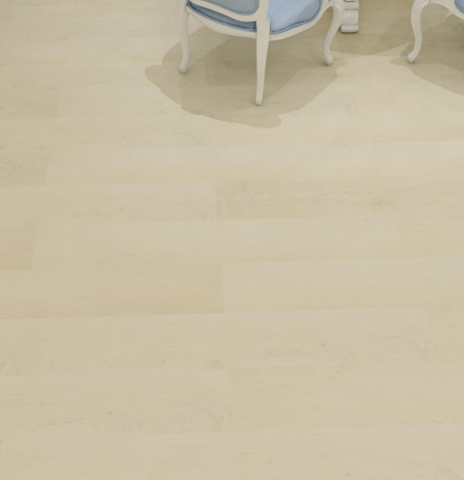 Pale wood floor with legs of blue chair in upper right.