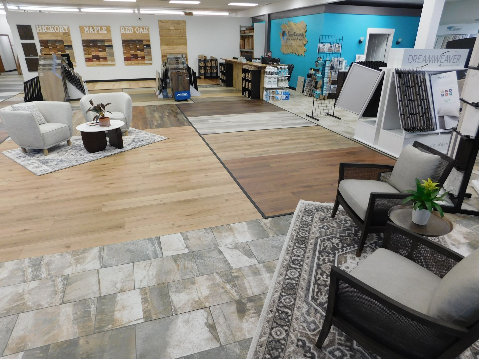 Interior of a flooring store. Displayed flooring samples, seating areas, and product displays.