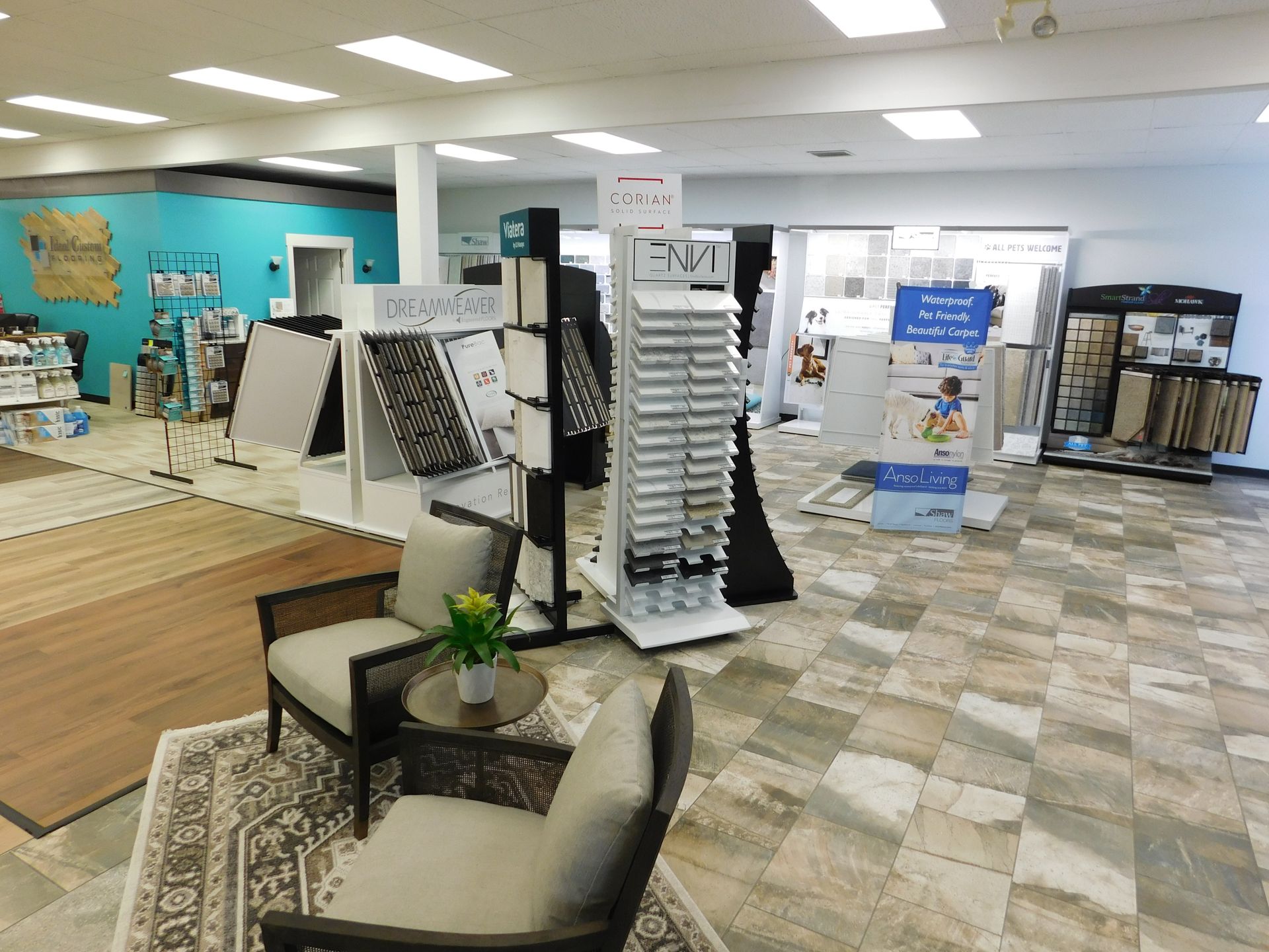 Interior of a flooring showroom, displaying samples, seating area, and various flooring types.