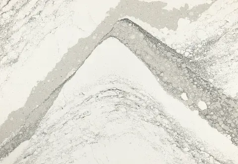 Abstract white and grey stone with a V-shaped design, resembling a mountain or zigzag pattern.