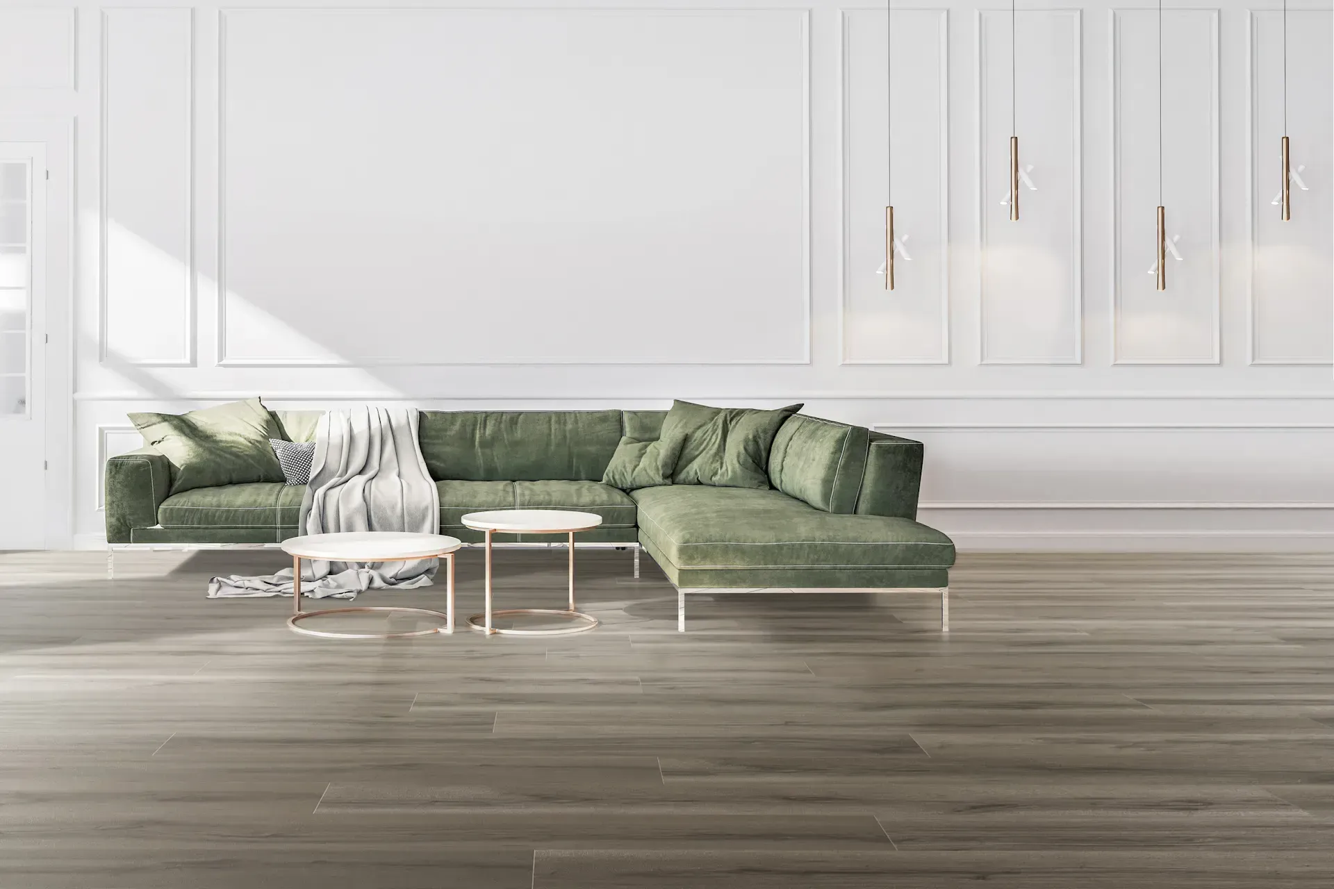 Green sectional sofa in a modern white room with two small tables and decorative hanging lights.