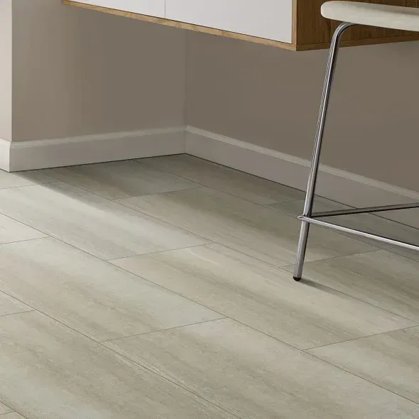 Light gray wood-look flooring beneath a white countertop and a chrome stool in a corner.