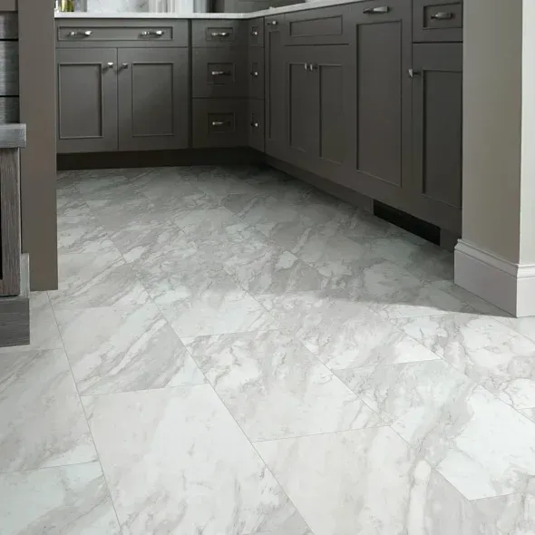 Marble-look flooring in a kitchen with gray cabinets.