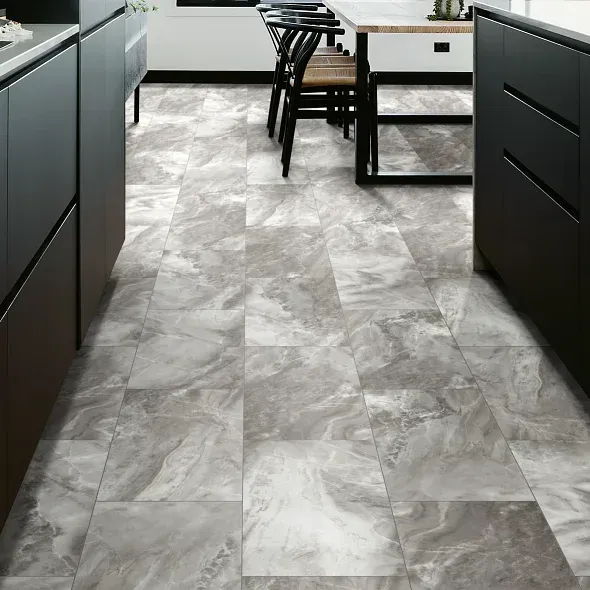 Gray marble-look floor tiles in a modern kitchen with dark cabinets and a table with chairs.