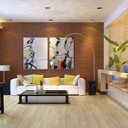 Living room with white sofa, yellow pillows, abstract art, and wood floor.