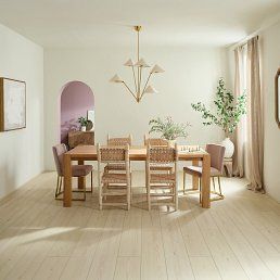 Dining room with a wooden table, chairs, and a chandelier; light floors, neutral walls, arched doorway.