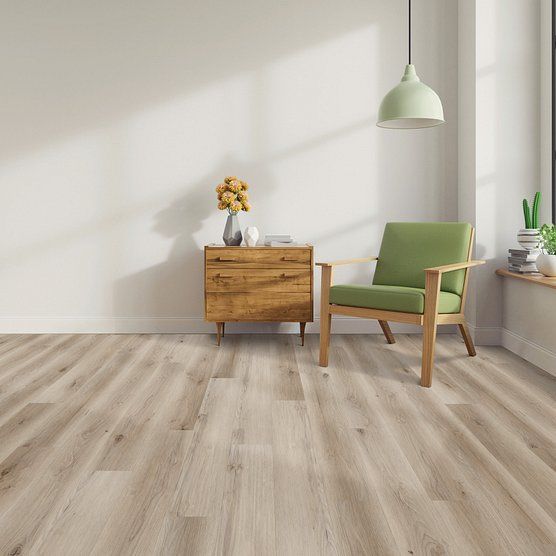Room with light wood floor, chest, green chair, window, and pendant light.