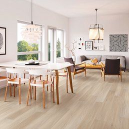 Modern dining and living room with light wood floors and white walls.