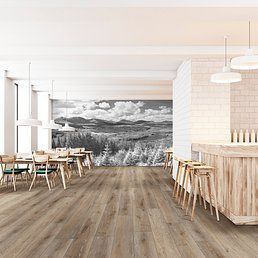 Restaurant interior with wood floors, a bar, tables, and a landscape mural.