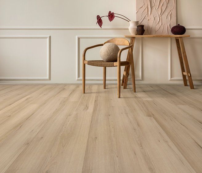 Light wood-floored room with a chair, table, and wall decor. Neutral colors create a calming atmosphere.