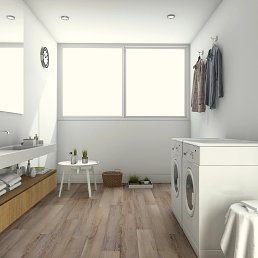Laundry room with washing machine, hanging clothes, and small side table with plants.