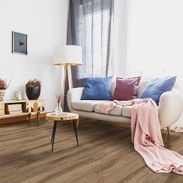 Living room with a couch, wooden floors, and a side table.