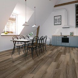 Dining room with wooden floor, table, chairs, kitchen, window, and pendant lights.