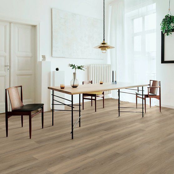 Dining room with wooden table and chairs, light wood floor, white walls, and large window.