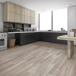 Modern kitchen with light wood floors, dark cabinets, light wood upper cabinets, and large windows.