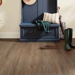 Blue hall tree with storage and decor on brown wood-look flooring.