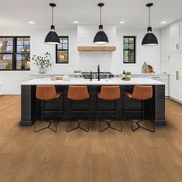 Modern kitchen with an island, bar stools, and hardwood floors.