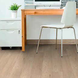 Office with a wooden desk, white chair, and filing cabinet; wood-look flooring.