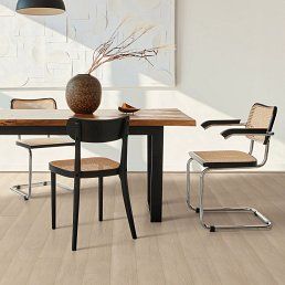 Dining room scene: wooden table, chairs, vase with twigs. Light-colored floor, minimalist design.