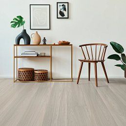 Interior with light wooden flooring, a console table, wooden chair, and wall art.