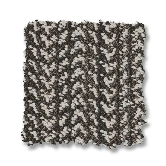 Close-up of a square carpet sample in a chevron pattern, with white and dark gray flecks.
