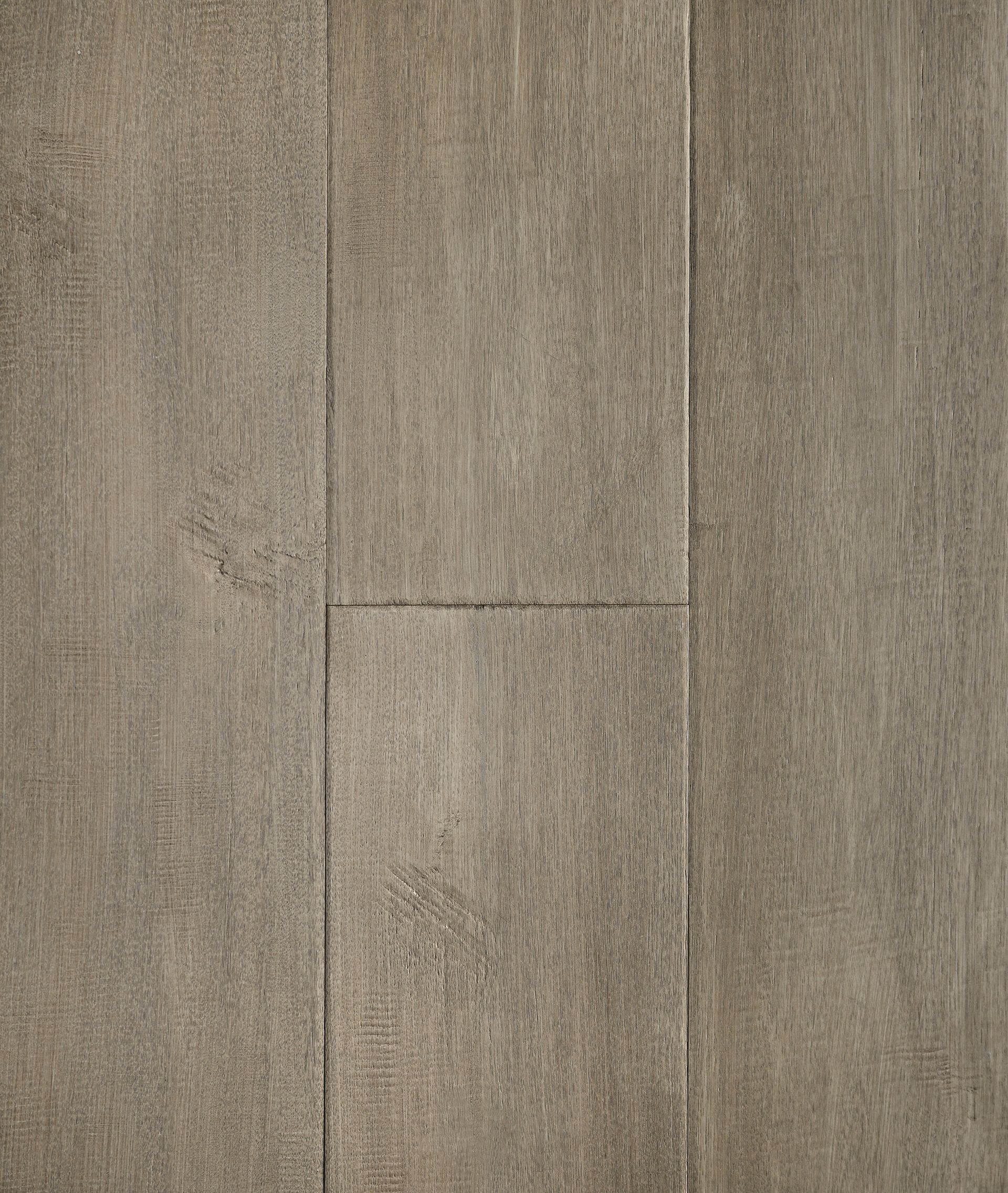 Close-up of light brown wood flooring, showing vertical planks with varying textures and grain.