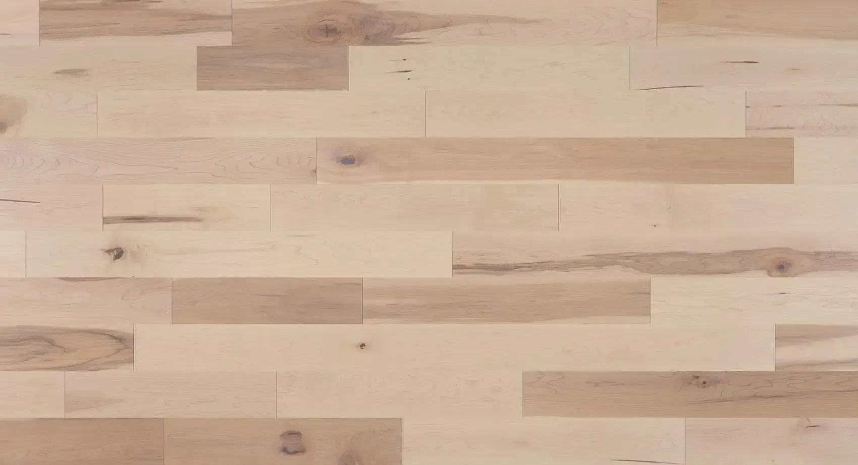 Light-colored hardwood floor with variations in color and wood grain.