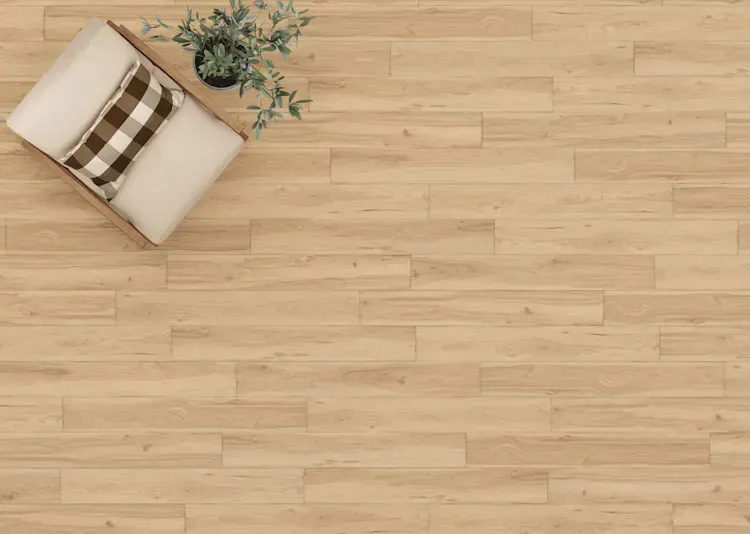 Chair with plaid pillow and plant on light wood floor.