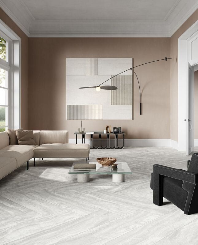 Living room with beige sectional, geometric artwork, and herringbone patterned floor.