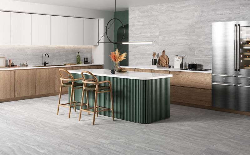 Modern kitchen with green island, wood cabinets, and stainless steel refrigerator.