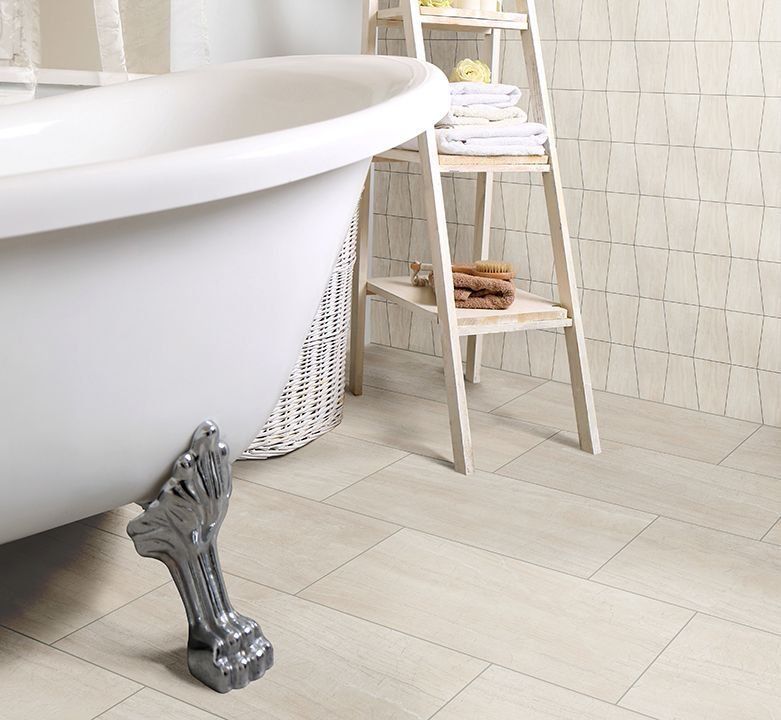 Claw-foot bathtub in a light-colored bathroom, with a wooden ladder holding towels and toiletries.