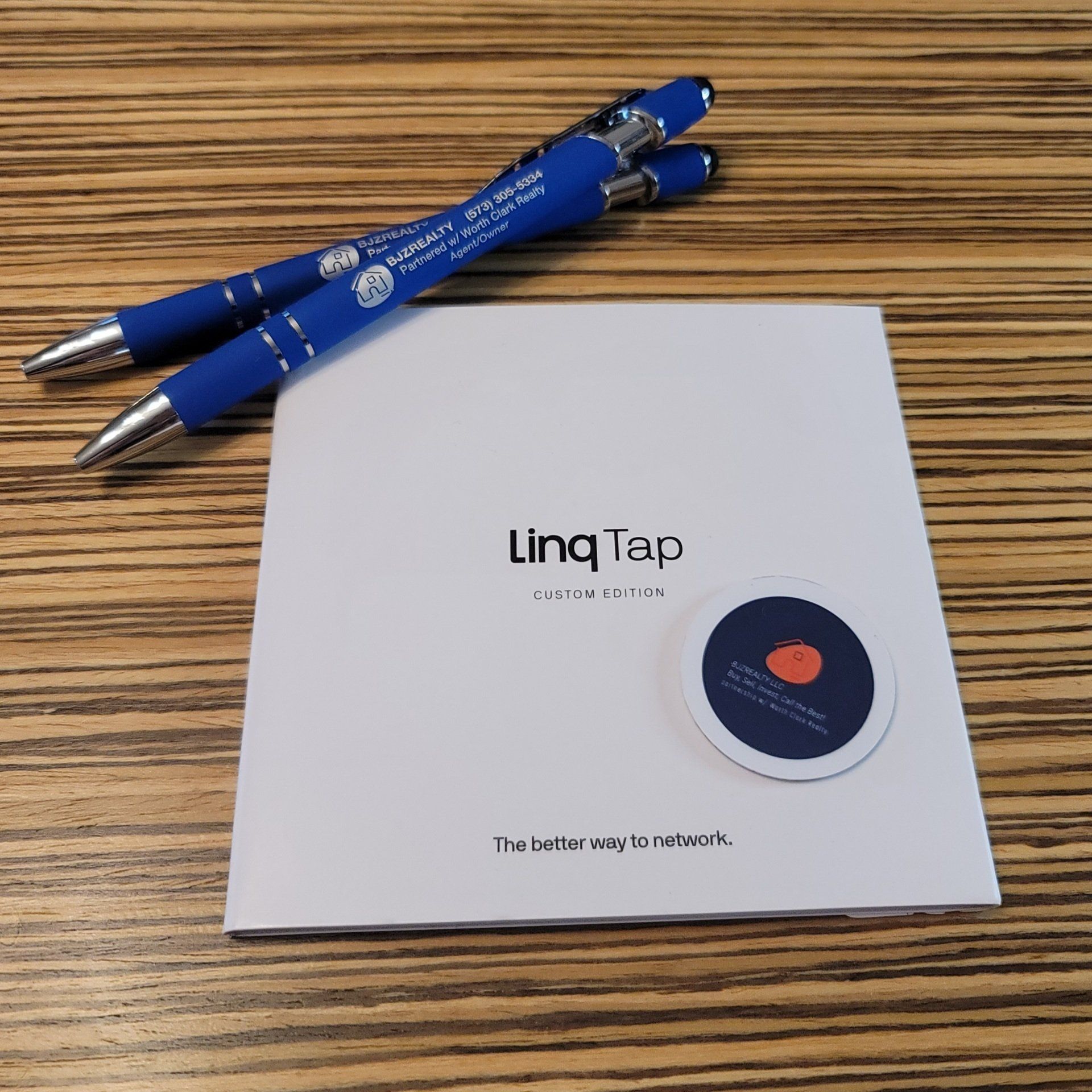 Two blue pens sit on top of a ling tap booklet