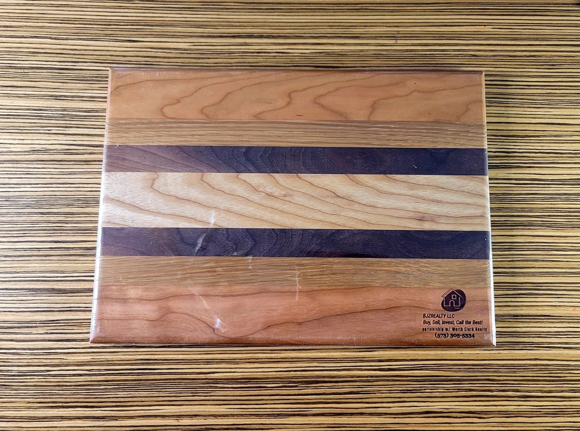 A wooden cutting board is sitting on a wooden table