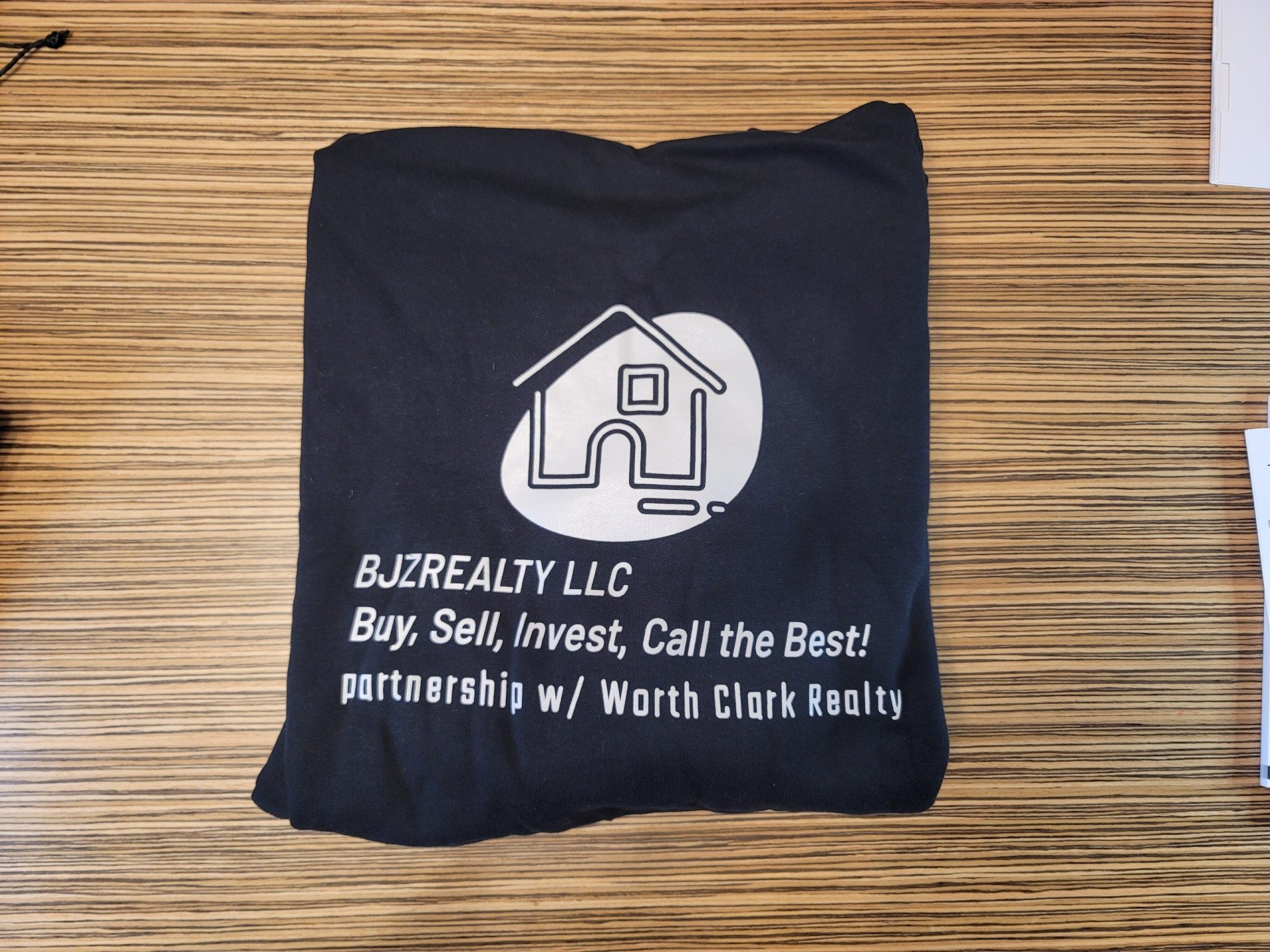A black shirt that says bjzrealty llc on it