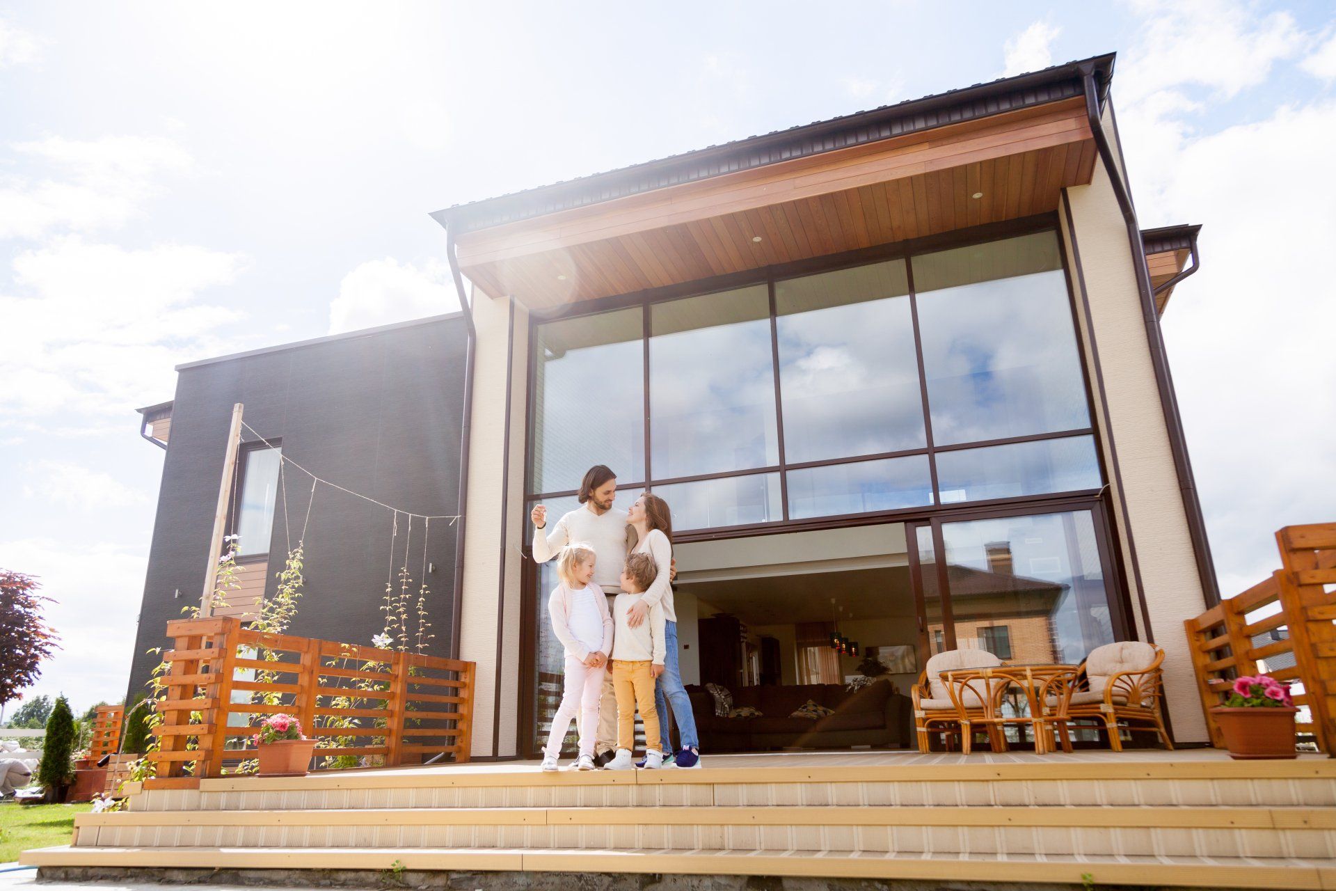 A family is standing on the steps of their new home.